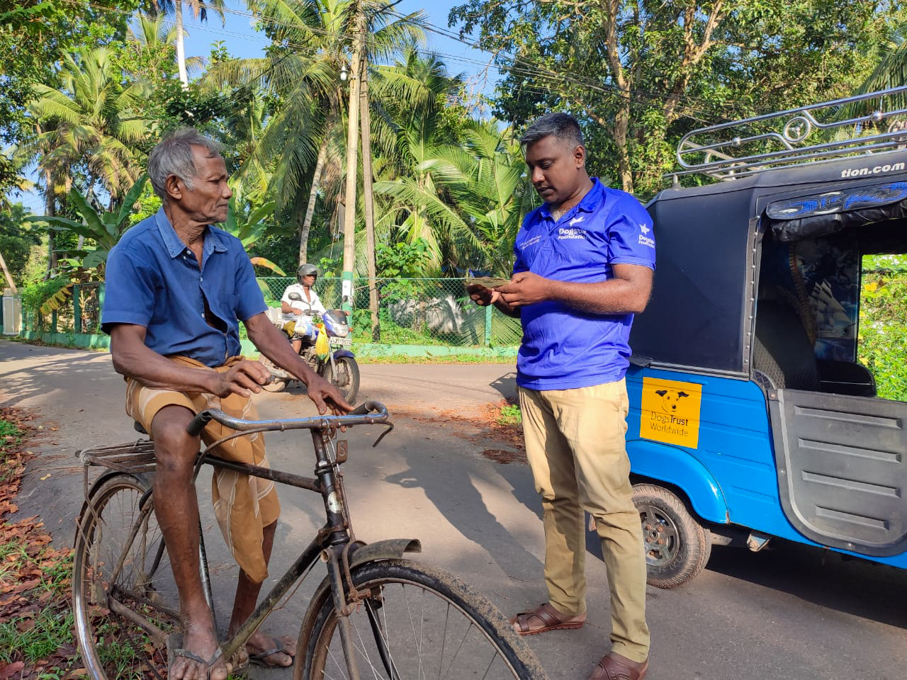 A Dogstar employee giving out an information leaflet to a man on a bike.